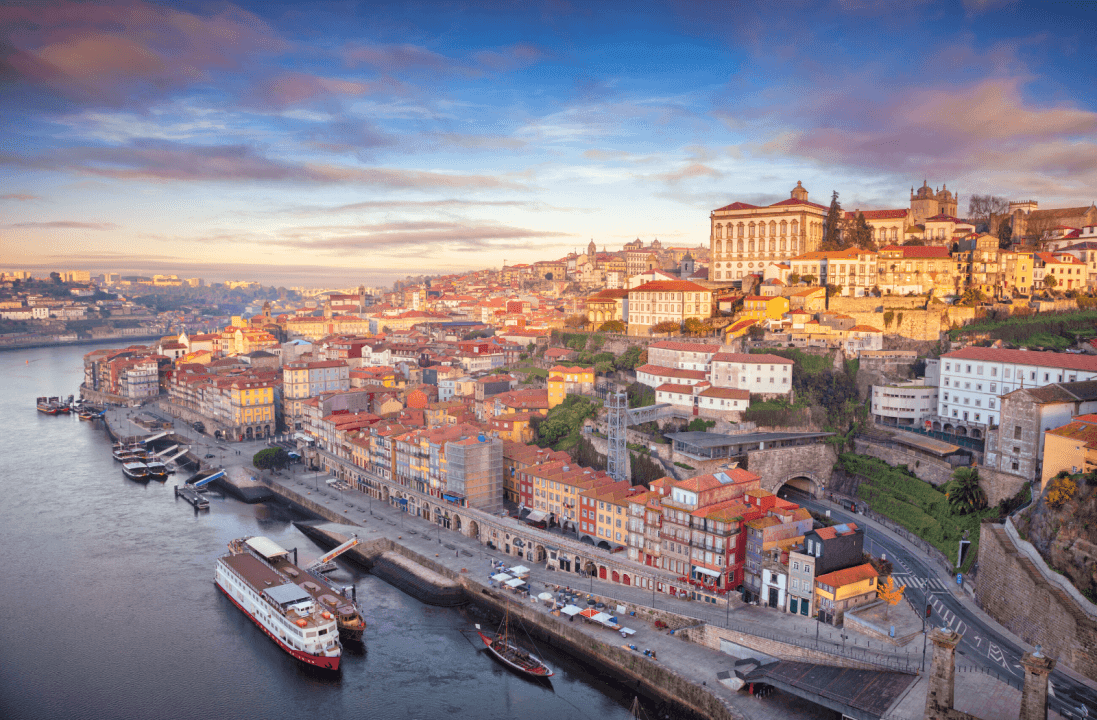 Scenic view of Porto, Portugal with colorful buildings along the Douro River at sunset.